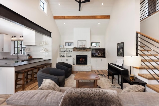 300 E Washington Ave, Breckenridge, CO 80424 - living area featuring light wood-style floors, high vaulted ceiling, beam ceiling, a fireplace, and stairs
