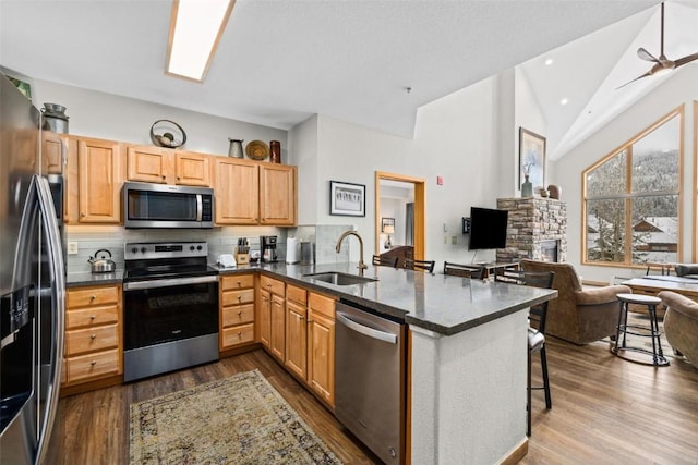 23110 US Highway 6 Unit 5044, Keystone, CO 80435 - kitchen featuring appliances with stainless steel finishes, a sink, a peninsula, tasteful backsplash, and open floor plan