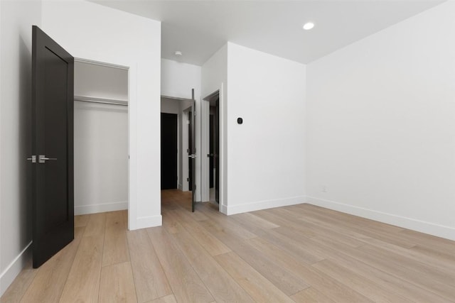 unfurnished bedroom featuring light hardwood / wood-style flooring and a closet