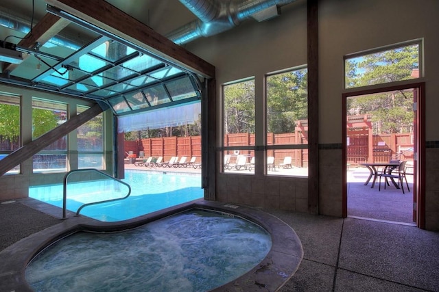 unfurnished sunroom with a pool and a hot tub