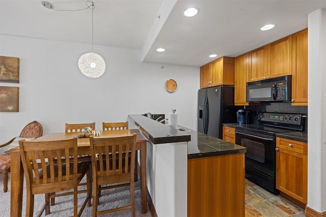 kitchen with recessed lighting, brown cabinets, decorative light fixtures, tile countertops, and black appliances