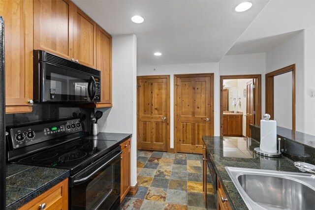 34 Highfield Trl Unit 203, Breckenridge, CO 80424 - kitchen featuring tile counters, brown cabinets, stone finish floor, a sink, and black appliances
