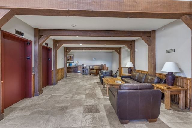 living area with wooden walls, elevator, and a wainscoted wall