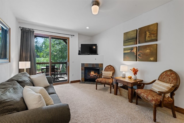 living room featuring a tiled fireplace, carpet flooring, and baseboards