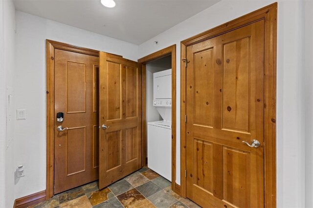 34 Highfield Trl Unit 203, Breckenridge, CO 80424 - washroom featuring stone finish floor, stacked washer and dryer, baseboards, and laundry area