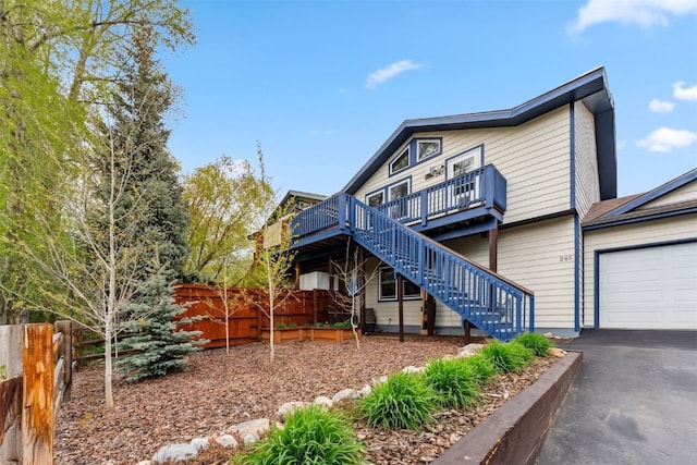 245 Tennis Ct, Silverthorne, CO 80498 - view of front of property with stairs, a wooden deck, driveway, and a garage