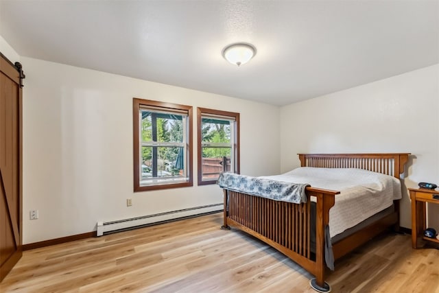 245 Tennis Ct, Silverthorne, CO 80498 - bedroom featuring a baseboard radiator, a barn door, and light wood finished floors