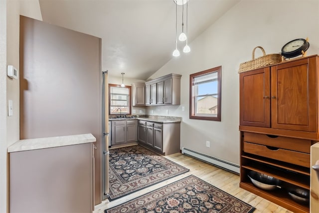 245 Tennis Ct, Silverthorne, CO 80498 - kitchen with a baseboard radiator, vaulted ceiling, gray cabinets, light wood finished floors, and plenty of natural light