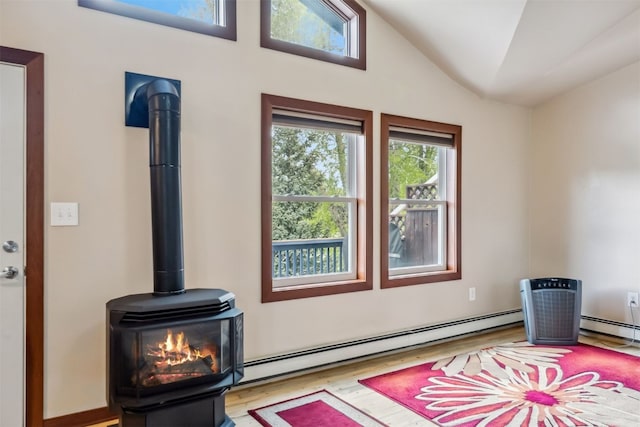 245 Tennis Ct, Silverthorne, CO 80498 - living area featuring a wood stove, a baseboard heating unit, wood finished floors, and lofted ceiling