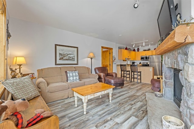 150 Dercum Sq Unit 8499, Keystone, CO 80435 - living room with light wood-type flooring, rail lighting, and a stone fireplace
