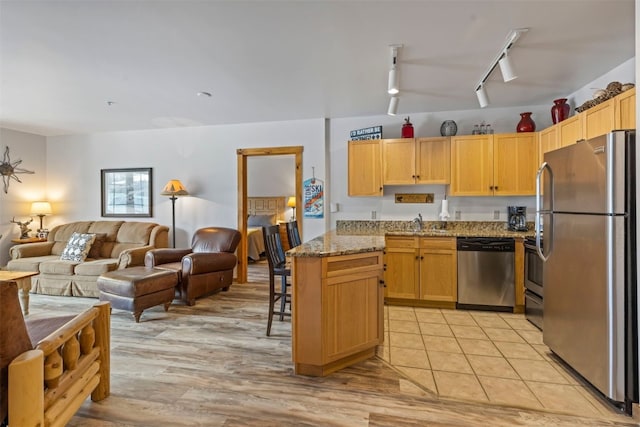 150 Dercum Sq Unit 8499, Keystone, CO 80435 - kitchen featuring appliances with stainless steel finishes, track lighting, open floor plan, and light stone countertops