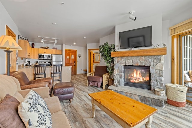 150 Dercum Sq Unit 8499, Keystone, CO 80435 - living room with light wood finished floors, a stone fireplace, and track lighting