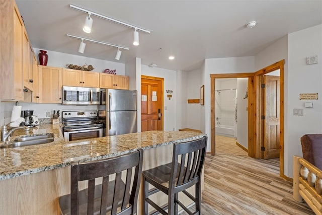 150 Dercum Sq Unit 8499, Keystone, CO 80435 - kitchen featuring stainless steel appliances, a sink, light brown cabinets, a peninsula, and light stone counters