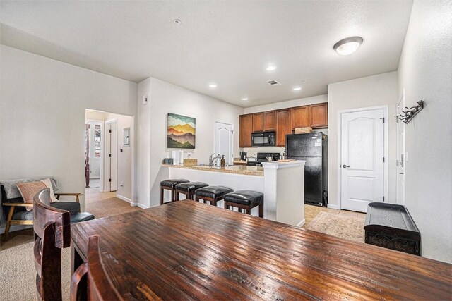 dining area featuring recessed lighting, baseboards, and light colored carpet