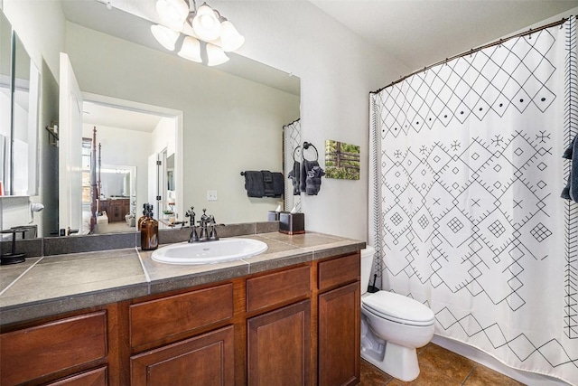 bathroom with tile patterned flooring, a wealth of natural light, toilet, and vanity
