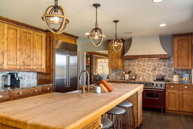 32505 County Road 20, Steamboat Springs, CO 80487 - kitchen featuring custom exhaust hood, high end appliances, butcher block counters, brown cabinets, and recessed lighting