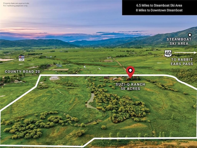 32505 County Road 20, Steamboat Springs, CO 80487 - aerial view at dusk of a mountain view, property boundaries highlighted, and a rural view