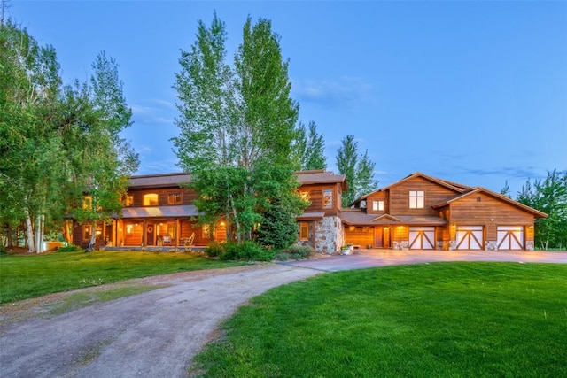 32505 County Road 20, Steamboat Springs, CO 80487 - view of front of property featuring concrete driveway, a front lawn, a garage, and a porch