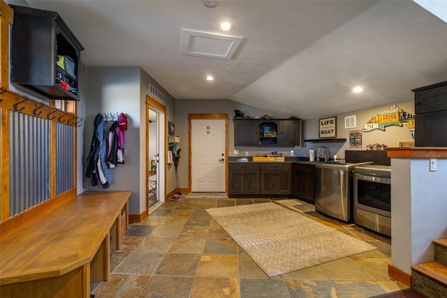 32505 County Road 20, Steamboat Springs, CO 80487 - kitchen featuring separate washer and dryer, stone finish flooring, baseboards, vaulted ceiling, and a peninsula