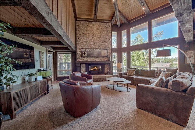 51 Salt Lick Cir Unit 51, Silverthorne, CO 80498 - living area with a wooden ceiling with exposed beams, carpet, a towering ceiling, and a stone fireplace