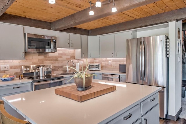 51 Salt Lick Cir Unit 51, Silverthorne, CO 80498 - kitchen with appliances with stainless steel finishes, decorative backsplash, light countertops, a wood ceiling with exposed beams, and a center island