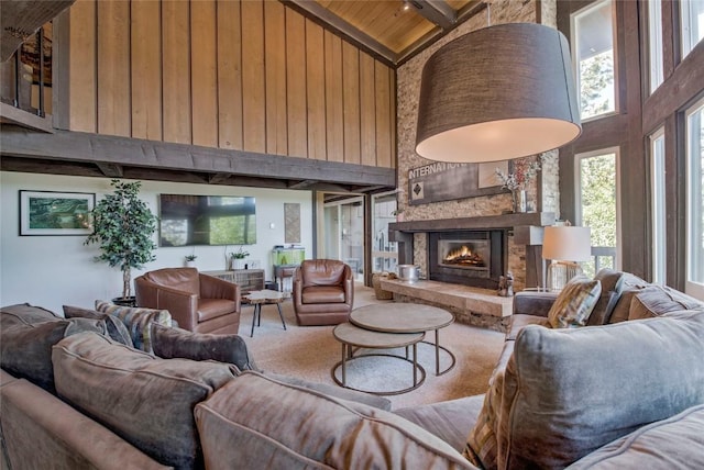 51 Salt Lick Cir Unit 51, Silverthorne, CO 80498 - carpeted living room featuring high vaulted ceiling, a wooden ceiling with exposed beams, healthy amount of natural light, a fireplace, and wood walls