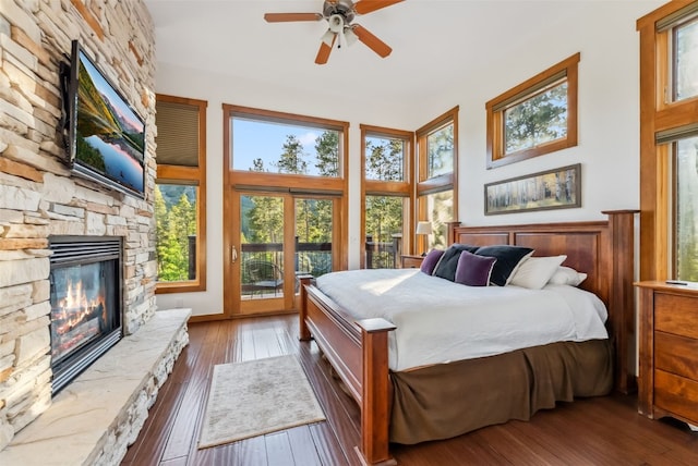 564 White Cloud Dr, Breckenridge, CO 80424 - bedroom featuring a stone fireplace, hardwood / wood-style flooring, and a ceiling fan
