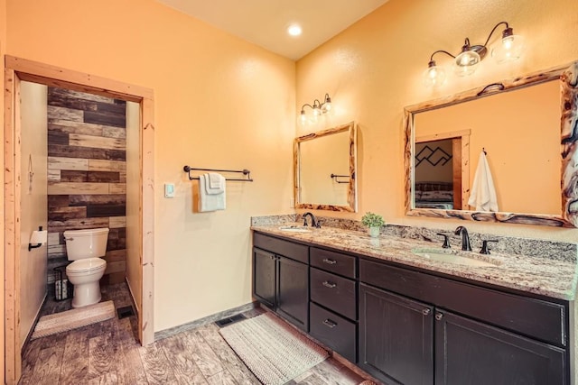 133 Lake Dr, Florissant, CO 80816 - full bath with wood finished floors, a sink, double vanity, and toilet