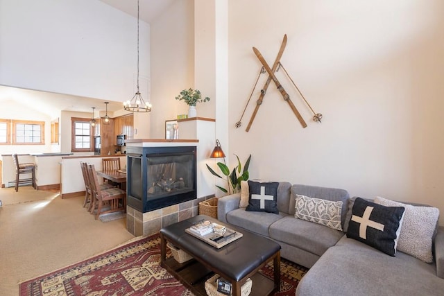 carpeted living room featuring a multi sided fireplace and a notable chandelier