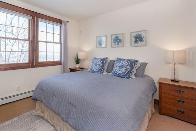 bedroom featuring light carpet and a baseboard radiator