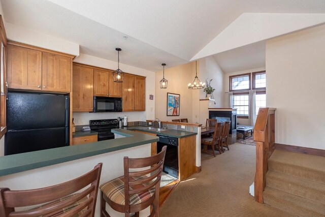 kitchen featuring carpet flooring, kitchen peninsula, vaulted ceiling, a kitchen bar, and black appliances