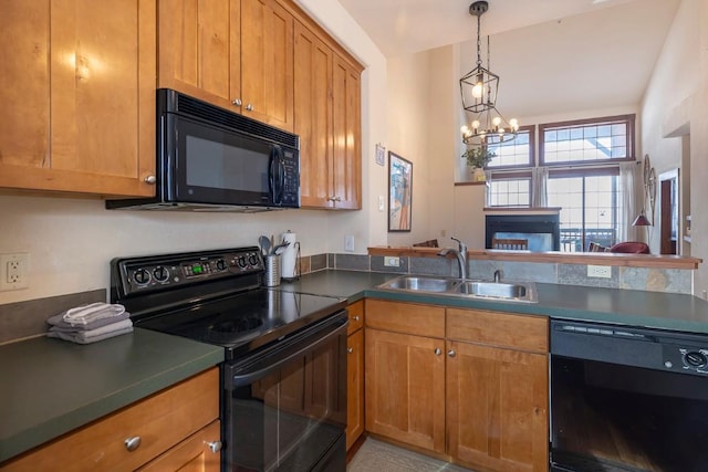 kitchen with black appliances, sink, decorative light fixtures, a notable chandelier, and kitchen peninsula