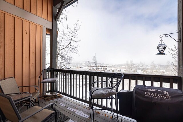 snow covered back of property featuring grilling area