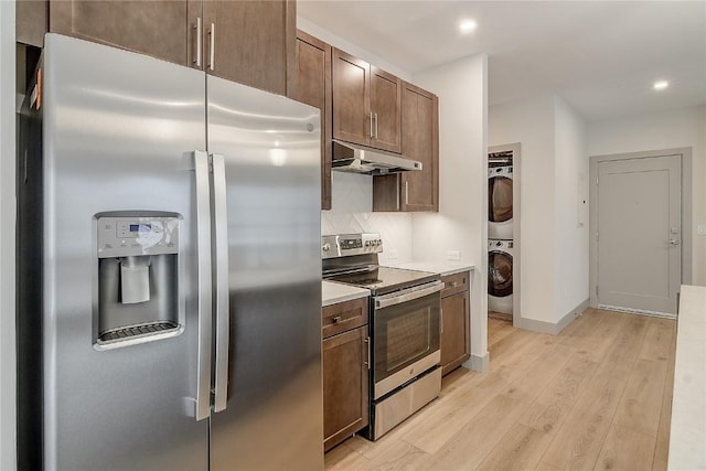 75 W 4th St Unit 204W, Silverthorne, CO 80498 - kitchen with light wood-type flooring, stainless steel appliances, under cabinet range hood, stacked washer and clothes dryer, and recessed lighting