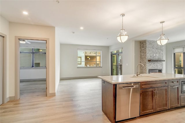 75 W 4th St Unit 204W, Silverthorne, CO 80498 - kitchen featuring a stone fireplace, a sink, open floor plan, dishwasher, and light countertops
