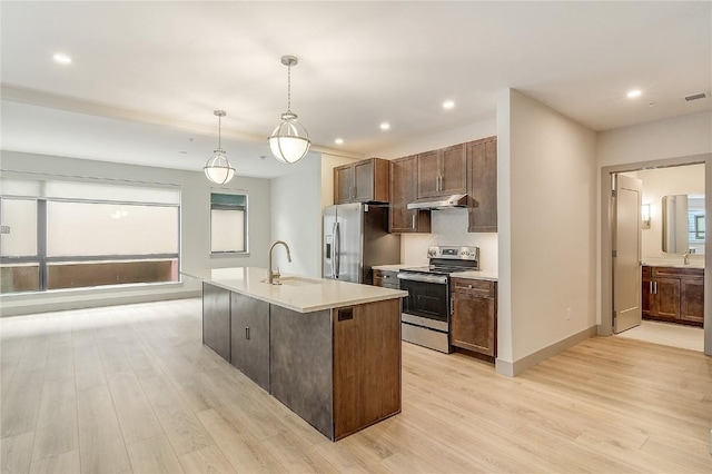 75 W 4th St Unit 204W, Silverthorne, CO 80498 - kitchen with light wood-style flooring, a sink, light countertops, under cabinet range hood, and appliances with stainless steel finishes