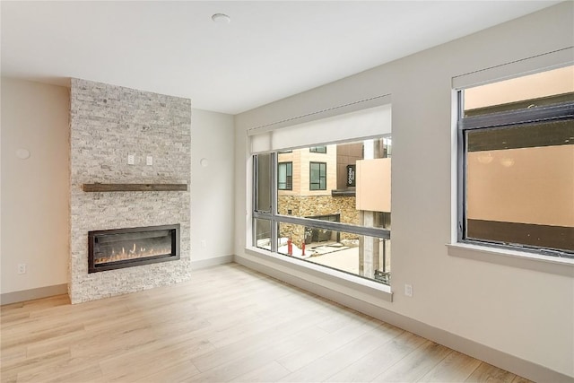75 W 4th St Unit 204W, Silverthorne, CO 80498 - unfurnished living room with a stone fireplace, a wealth of natural light, and wood finished floors