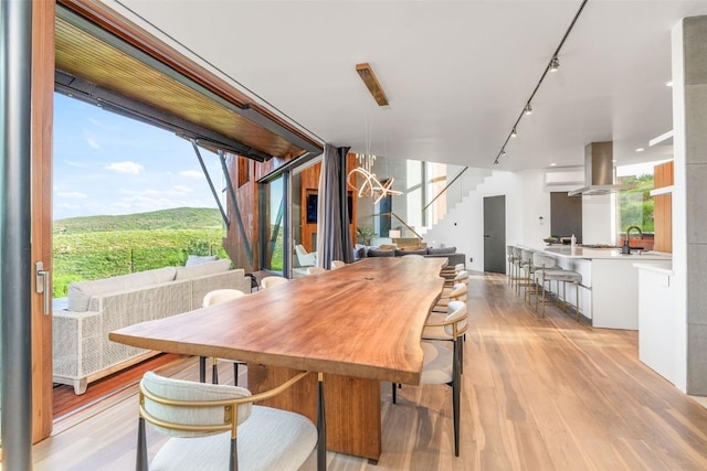 806 Amethyst Dr, Steamboat Springs, CO 80487 - dining space featuring track lighting, light wood-style flooring, a wealth of natural light, and stairs