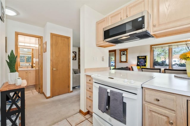 480 Ore House Plz Unit 106, Steamboat Springs, CO 80487 - kitchen with white electric stove, light brown cabinetry, light countertops, and light colored carpet