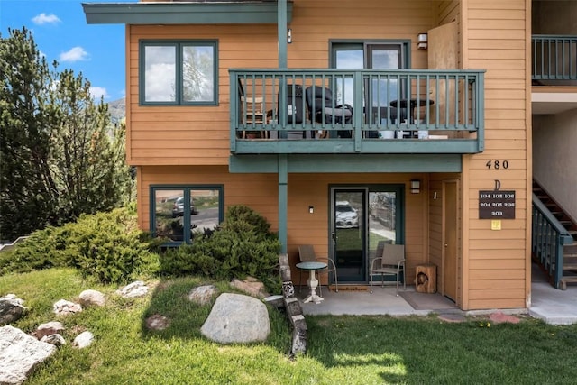 480 Ore House Plz Unit 106, Steamboat Springs, CO 80487 - rear view of property featuring a balcony, a patio area, stairway, and a yard