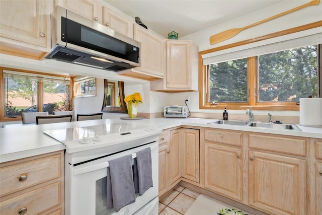 480 Ore House Plz Unit 106, Steamboat Springs, CO 80487 - kitchen with light brown cabinetry, stainless steel microwave, white electric stove, and a sink