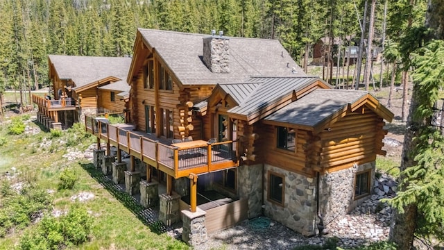 665 Whispering Pines Ln, Breckenridge, CO 80424 - rear view of property with log siding, stone siding, a standing seam roof, and a view of trees