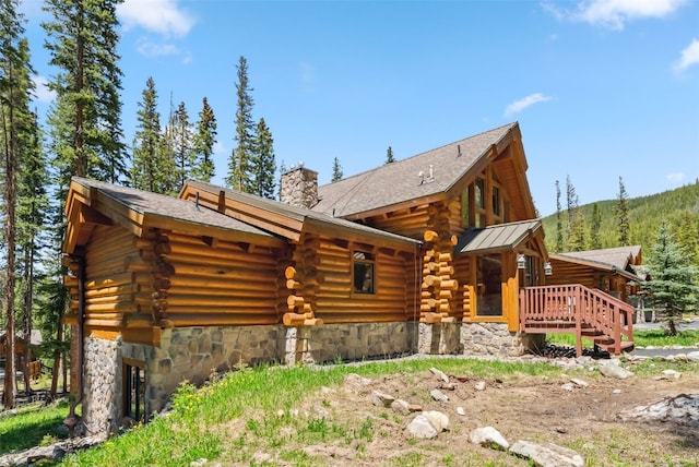 665 Whispering Pines Ln, Breckenridge, CO 80424 - back of house with log exterior, a chimney, and stone siding