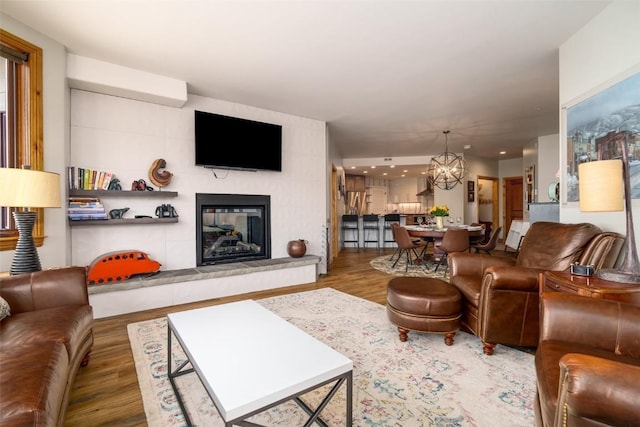 1875 Ski Time Square Dr Unit 711, Steamboat Springs, CO 80487 - living room featuring a tiled fireplace, wood finished floors, an inviting chandelier, and recessed lighting
