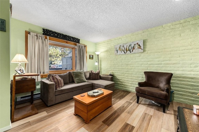 21 Balsam Ct, Steamboat Springs, CO 80487 - living area with a baseboard radiator, light wood-type flooring, a textured ceiling, and brick wall