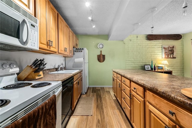 21 Balsam Ct, Steamboat Springs, CO 80487 - kitchen featuring brown cabinets, a sink, white appliances, light wood-type flooring, and a textured ceiling