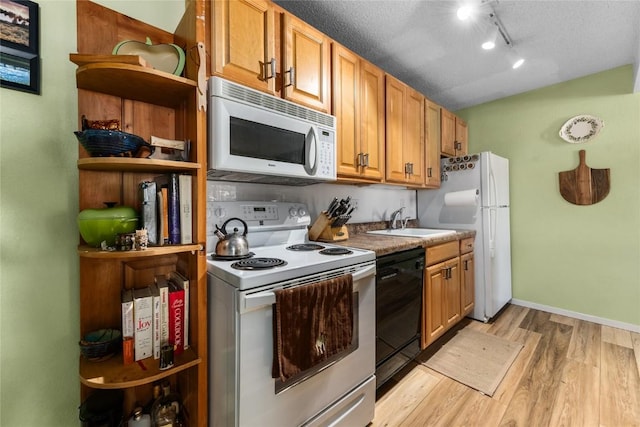 21 Balsam Ct, Steamboat Springs, CO 80487 - kitchen with open shelves, a sink, light wood-style floors, white appliances, and rail lighting