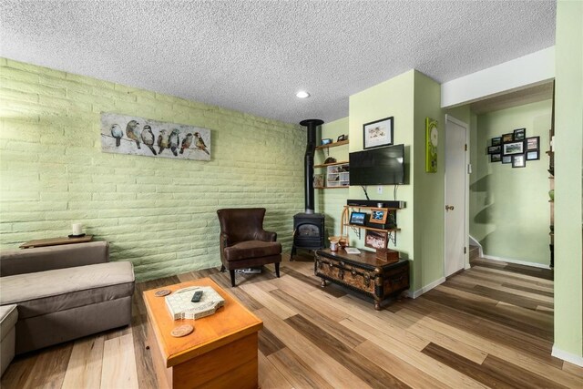 21 Balsam Ct, Steamboat Springs, CO 80487 - living room featuring brick wall, wood finished floors, a textured ceiling, and a wood stove