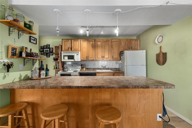 21 Balsam Ct, Steamboat Springs, CO 80487 - kitchen featuring a peninsula, a sink, dark countertops, white appliances, and open shelves