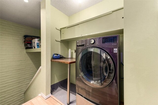 21 Balsam Ct, Steamboat Springs, CO 80487 - laundry area with washer / dryer, a textured ceiling, and baseboards